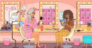 Two women sitting in a dressing room. One holds a phone, wearing a pink robe, and the other reads a book titled Romance. The room has a vanity mirror with lights, a pink locker, and various beauty items scattered around.