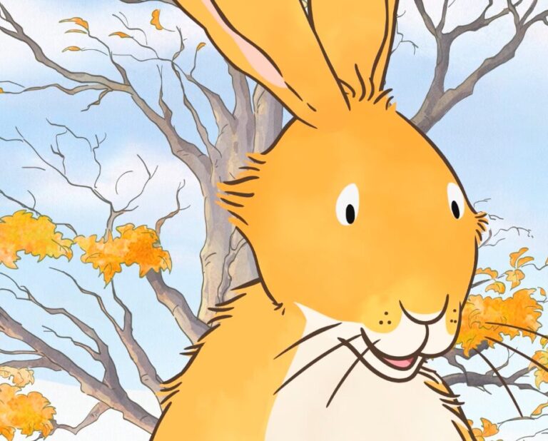 Illustration of a cheerful rabbit with light orange fur and large ears, set against a backdrop of bare branches and autumn leaves.